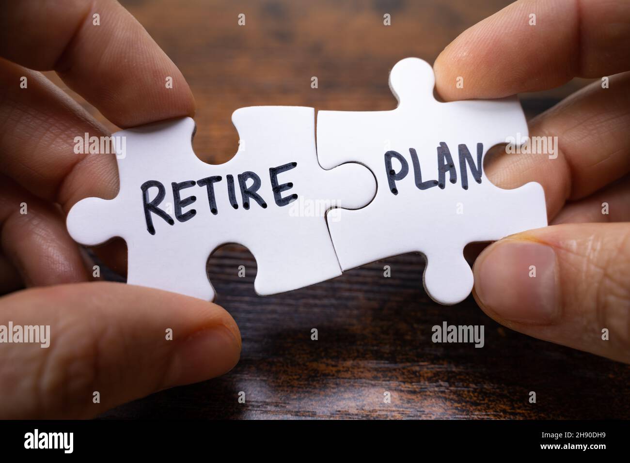 Mains tenant le plan de retraite Matching pièces de scie sauteuse contre le bois Banque D'Images
