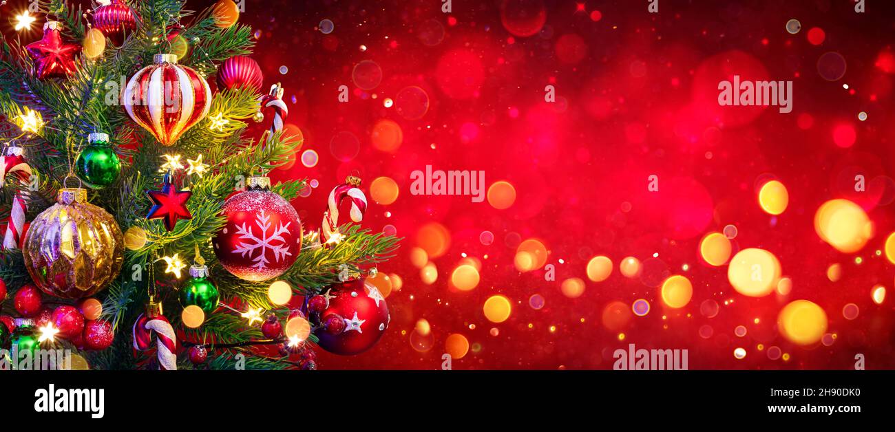 Sapin de Noël sur fond rouge - décorations et lumières évocacées abstraites Banque D'Images