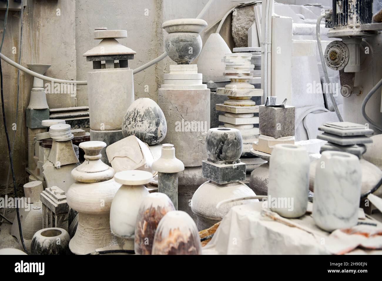 Beaucoup de pots et vases en pierre empilés ensemble à l'intérieur d'un atelier professionnel en marbre avec des murs en béton Banque D'Images