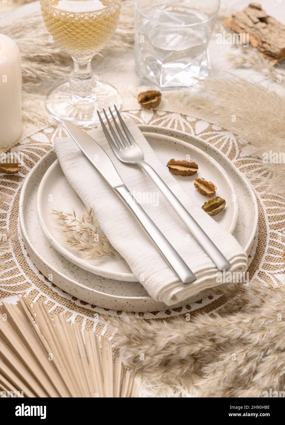 Table de mariage Bohemian place avec fourchette et couteau sur une serviette  sur platemat bohème de près.Boho assiettes tropicales, verres et bougie  près de drie Photo Stock - Alamy