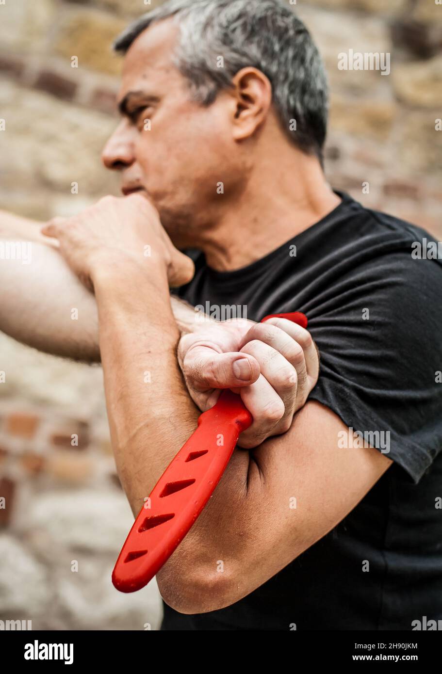 Démonstration du désarmement du couteau.Un instructeur de Kaap pratique les arts martiaux auto-défense couteau menace technique de désarmement.Formation sur la rétention et le désarmement des armes Banque D'Images