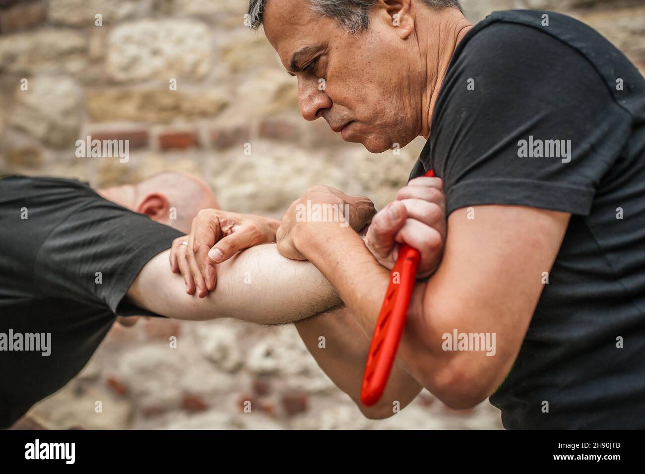 Démonstration du désarmement du couteau.Un instructeur de Kaap pratique les arts martiaux auto-défense couteau menace technique de désarmement.Formation sur la rétention et le désarmement des armes Banque D'Images