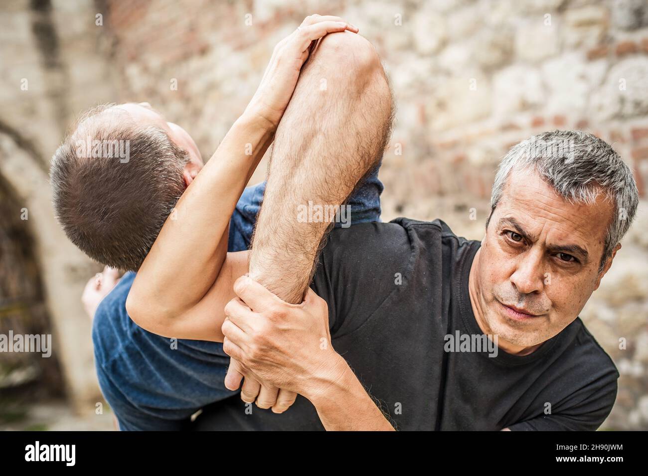 Démonstration du désarmement du couteau.Un instructeur de Kaap pratique les arts martiaux auto-défense couteau menace technique de désarmement.Formation sur la rétention et le désarmement des armes Banque D'Images