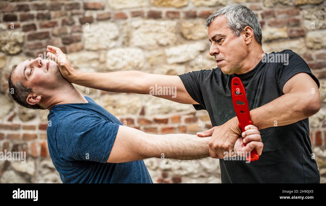 Démonstration du désarmement du couteau.Un instructeur de Kaap pratique les arts martiaux auto-défense couteau menace technique de désarmement.Formation sur la rétention et le désarmement des armes Banque D'Images