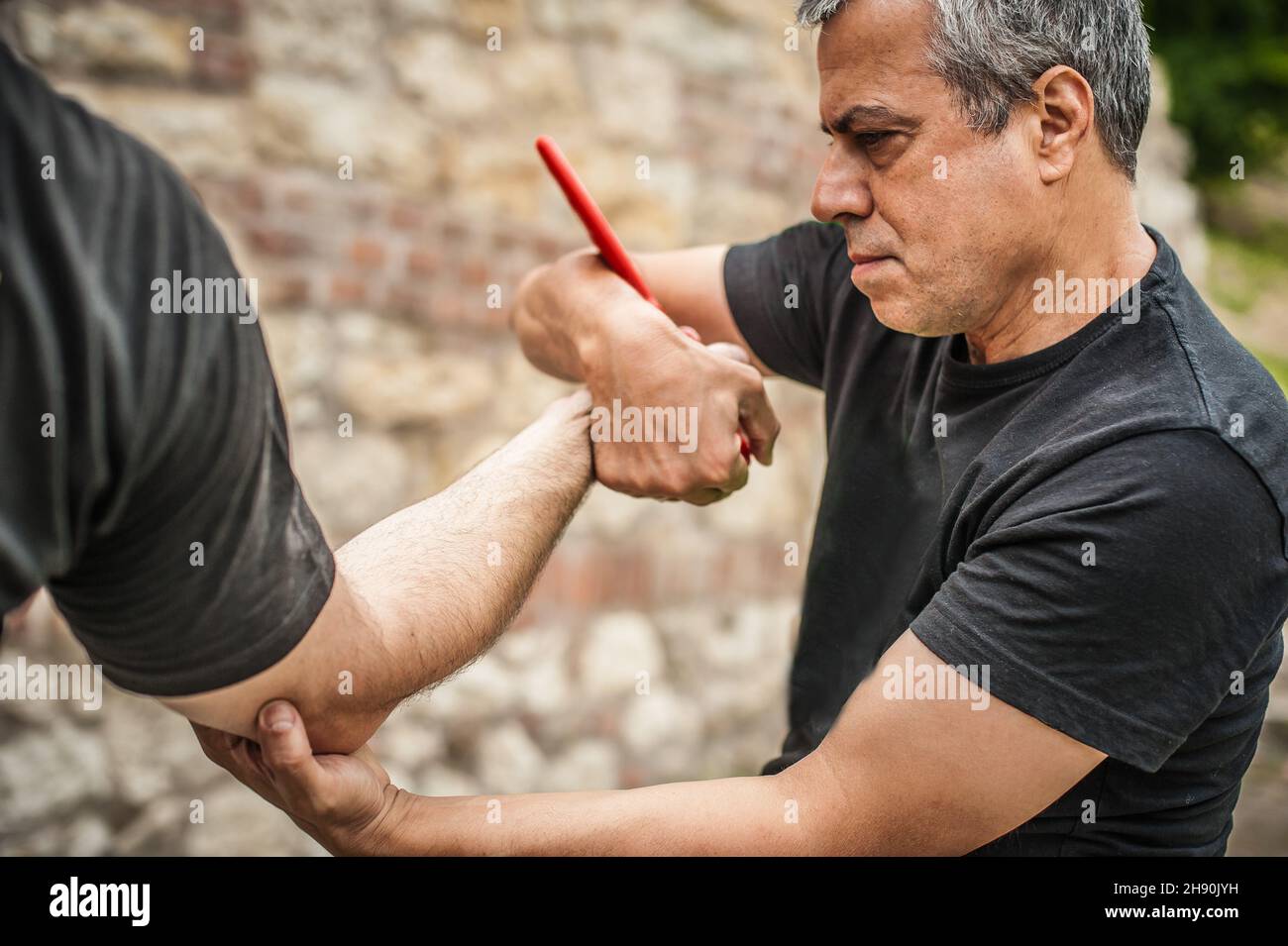 Démonstration du désarmement du couteau.Un instructeur de Kaap pratique les arts martiaux auto-défense couteau menace technique de désarmement.Formation sur la rétention et le désarmement des armes Banque D'Images