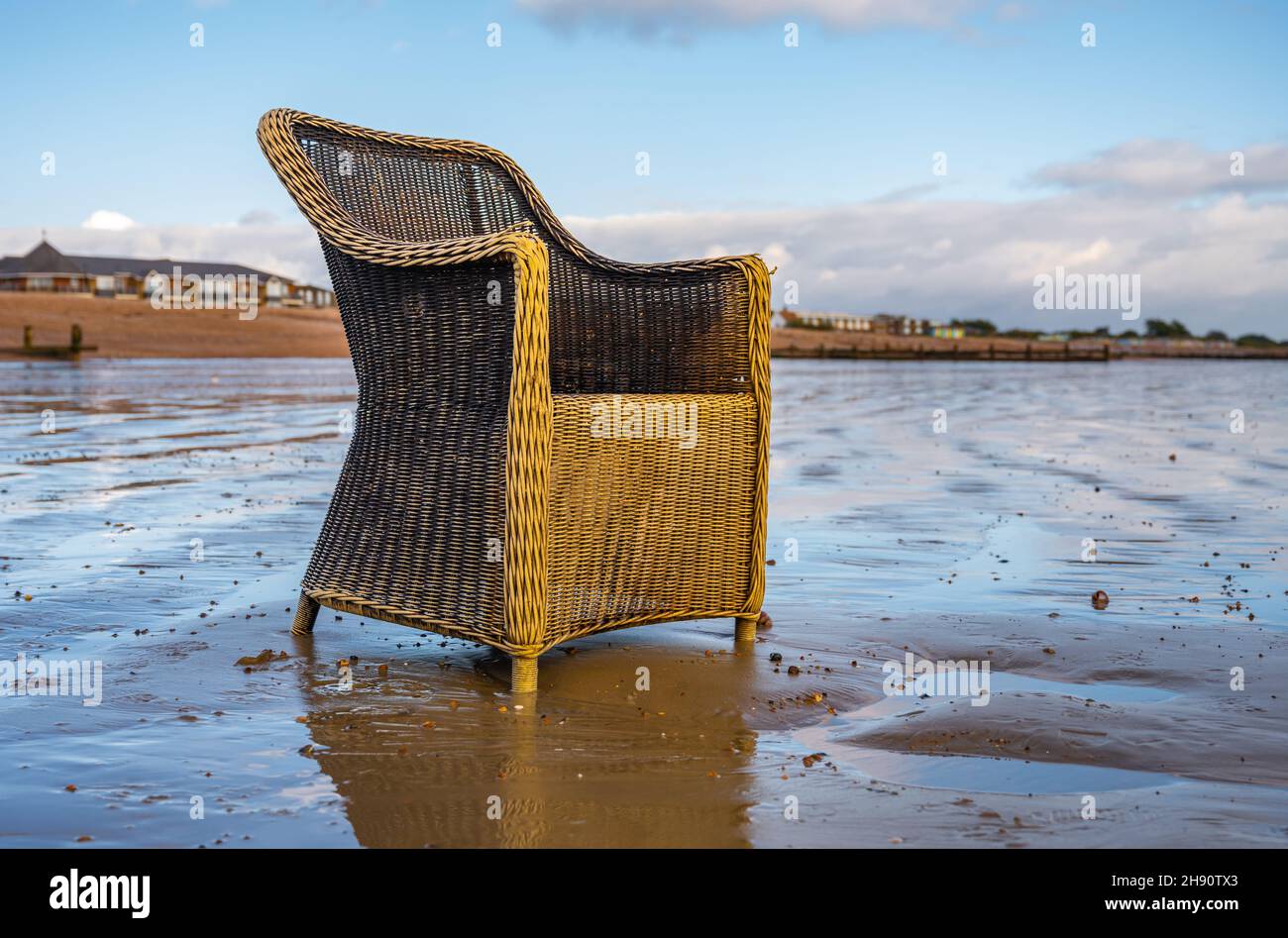 Vieux fauteuil jeté et indésirable sur une plage déserte au Royaume-Uni.Meubles abandonnés ou de la malbouffe de plage qui jonque une plage. Banque D'Images