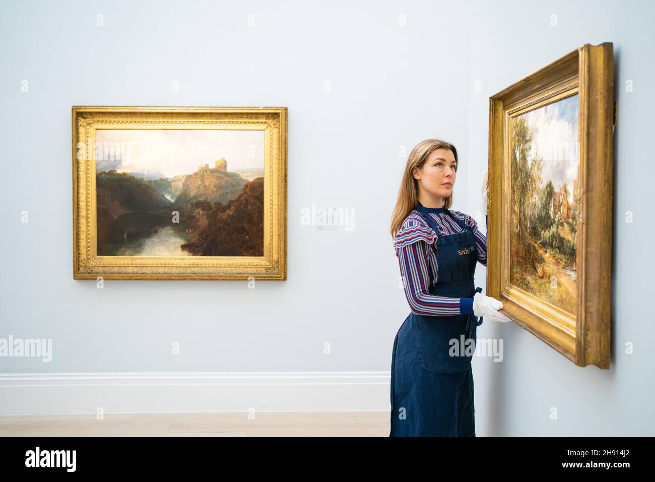 Un maître d'art de Sotheby avec 'Cilgerran Castle, pays de Galles' (à gauche) par J.M.W.Turner, d'une valeur de 300,000 £ à 500,000 £, et « The Glebe Farm » (à droite) par John Constable, d'une valeur de 3,000,000 £ à 5,000,000 £, lors d'un appel photo à Sotheby's à Mayfair, Londres, pour leur prochaine vente en soirée Old Masters, qui inclut une étude redécouverte par John Constable,Une paire de portraits rarement vus par Sir Anthony Van Dyck et une peinture à l'huile récemment redécouverte par JMW Turner.Date de la photo: Vendredi 3 décembre 2021. Banque D'Images