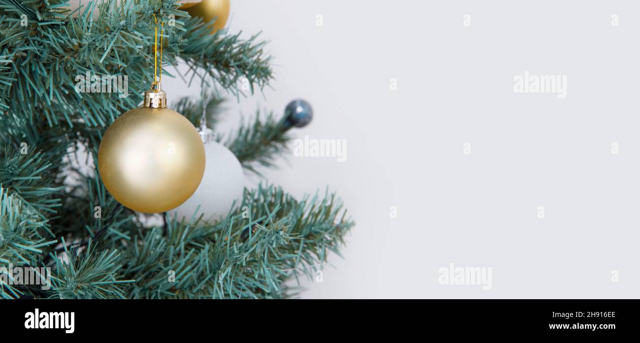 Bannière de Noël avec guirlande d'arbres de noël et ornements.Contexte de la nouvelle année.Boules et rubans d'or suspendus.Affiche supérieure horizontale de Noël pour Banque D'Images