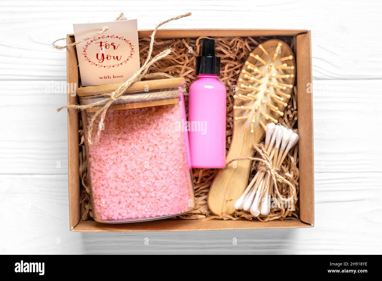 Kit pour coffret d'entretien cosmétiques écologiques sel de bain, peigne, savon fait à la main, bouteilles d'huile, éponge pour laver sur fond de bois cadeau pour petite amie Banque D'Images
