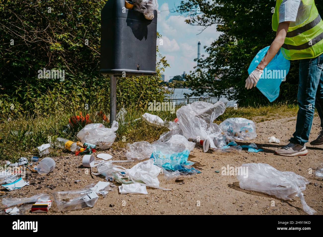 Une petite section de volontaires masculins collectant les déchets plastiques dans la poubelle Banque D'Images