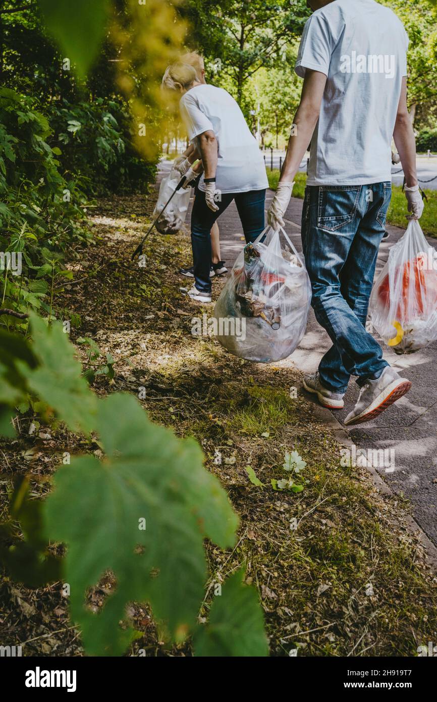 Les écologistes hommes et femmes ramassant les déchets dans le parc Banque D'Images