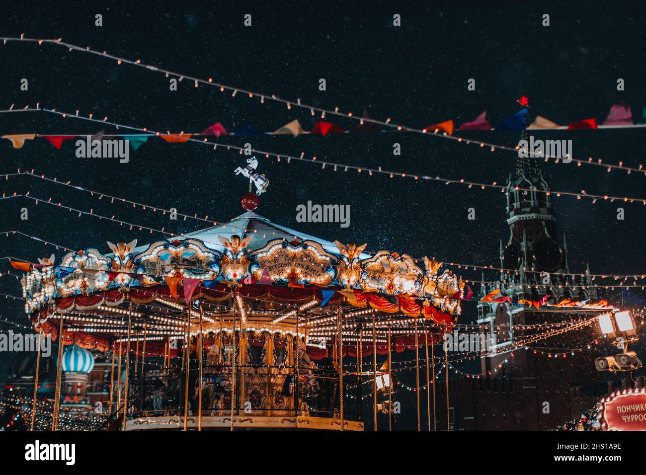 Fête des enfants Joyeux Go Round Carousel amusant dans l'atmosphère du nouvel an avec de la neige volante.Vacances magiques à Moscou Banque D'Images