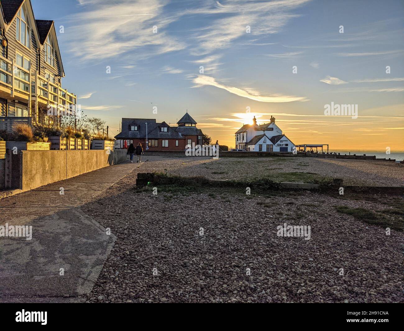 Le soleil se couche derrière le pub Old Neptune sur la plage Whitstable à la fin d'une belle journée Banque D'Images