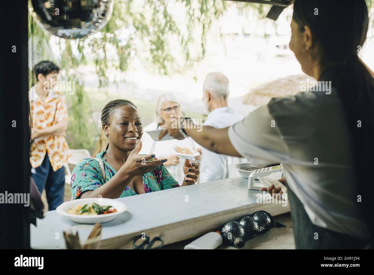 Femme vendeur servant de la nourriture au client dans le parc Banque D'Images
