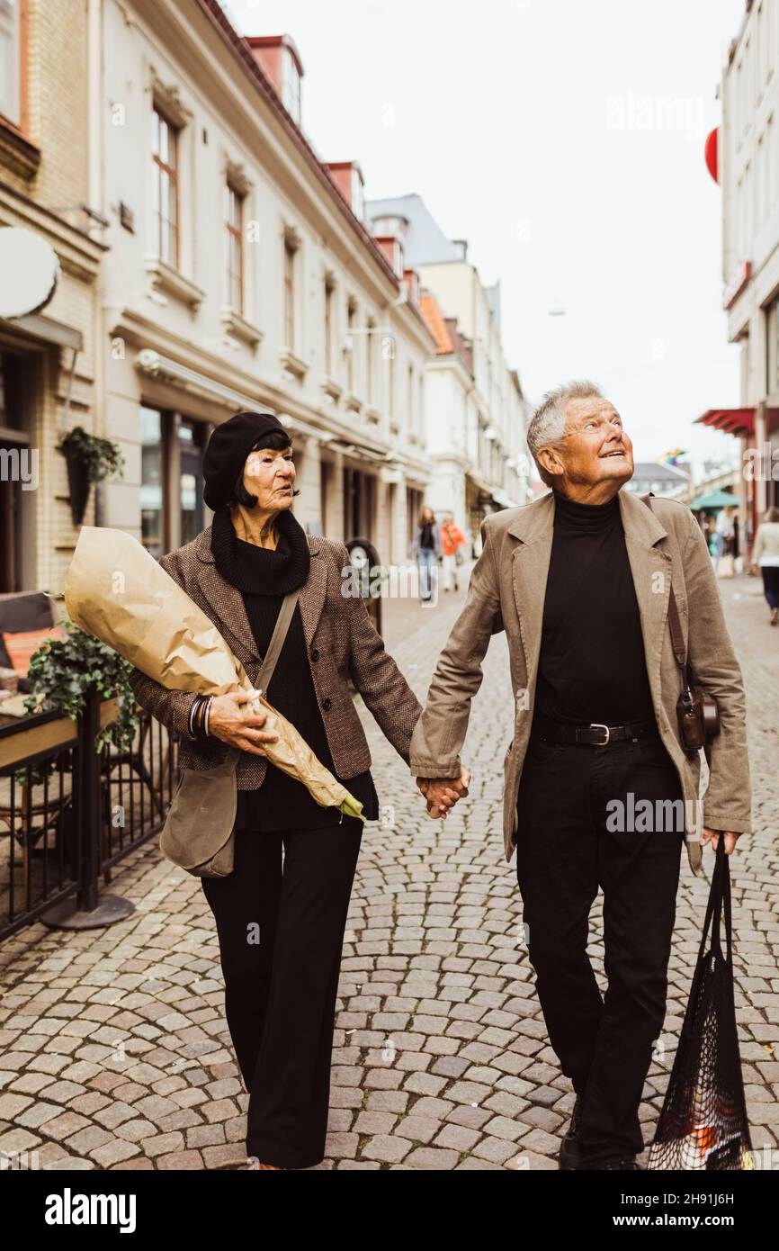 Couple senior tenant la main tout en explorant la ville pendant les vacances Banque D'Images