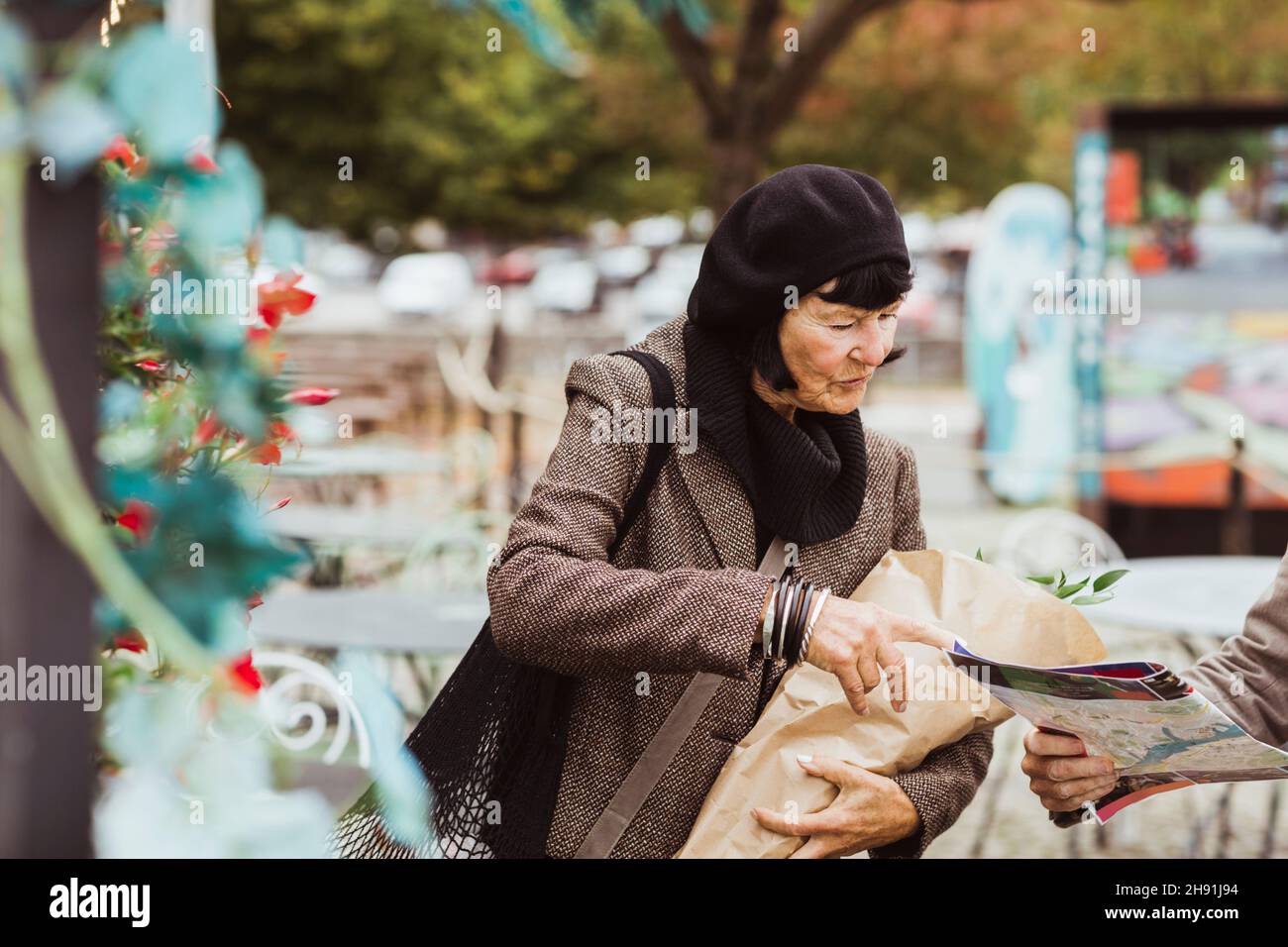 Femme âgée cherchant un emplacement sur la carte dans le parc Banque D'Images