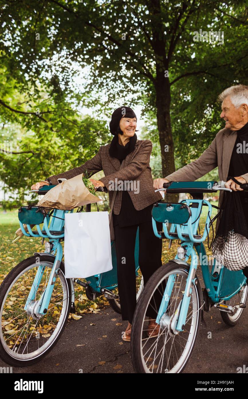 Couple de personnes âgées avec vélos électriques dans la rue pendant les vacances Banque D'Images