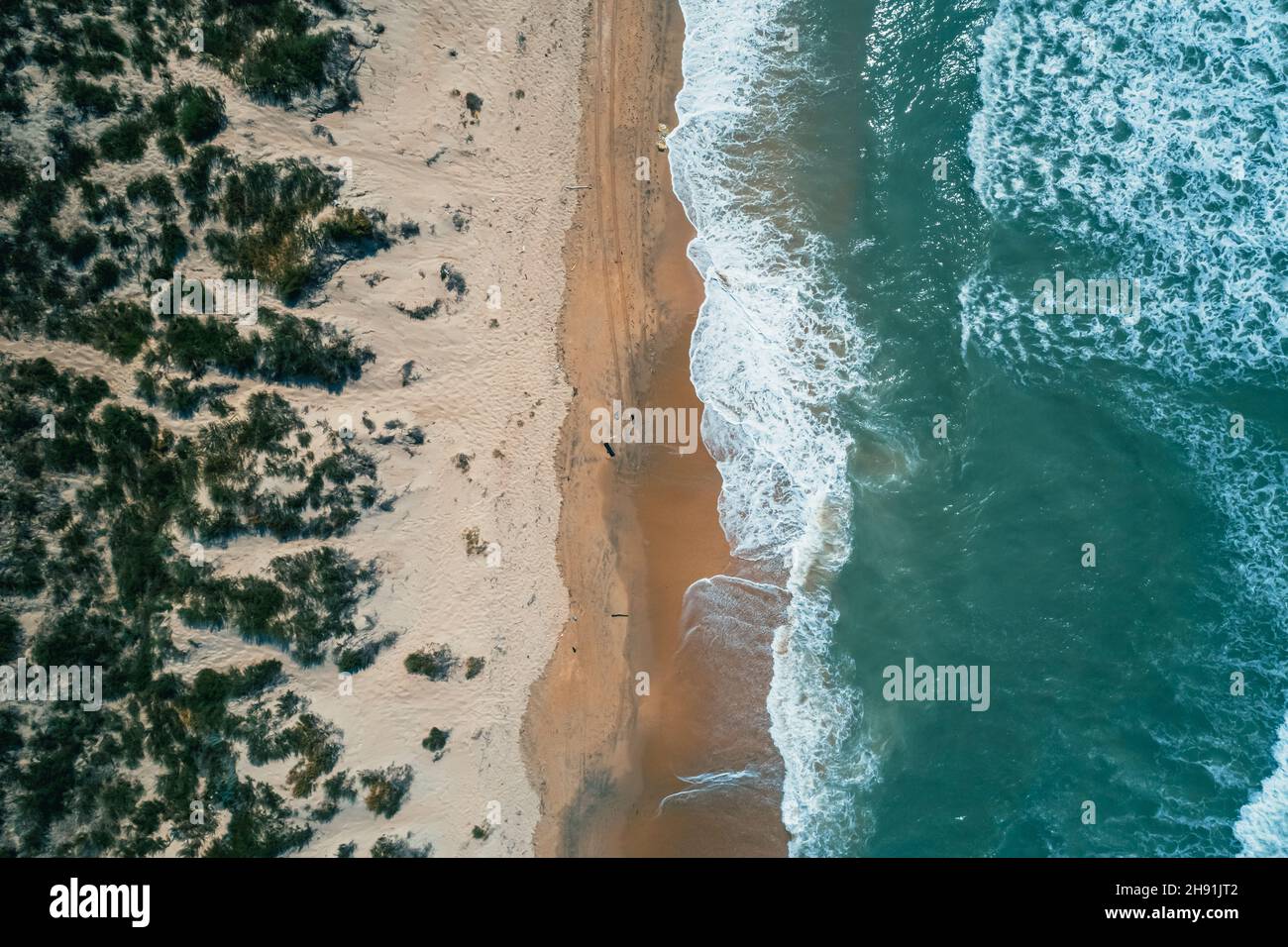 Photo aérienne de haut en bas de la mer et des vagues qui s'écrasées.Belle plage de sable et eaux marines tropicales turquoise.Un paysage estival parfait. Banque D'Images