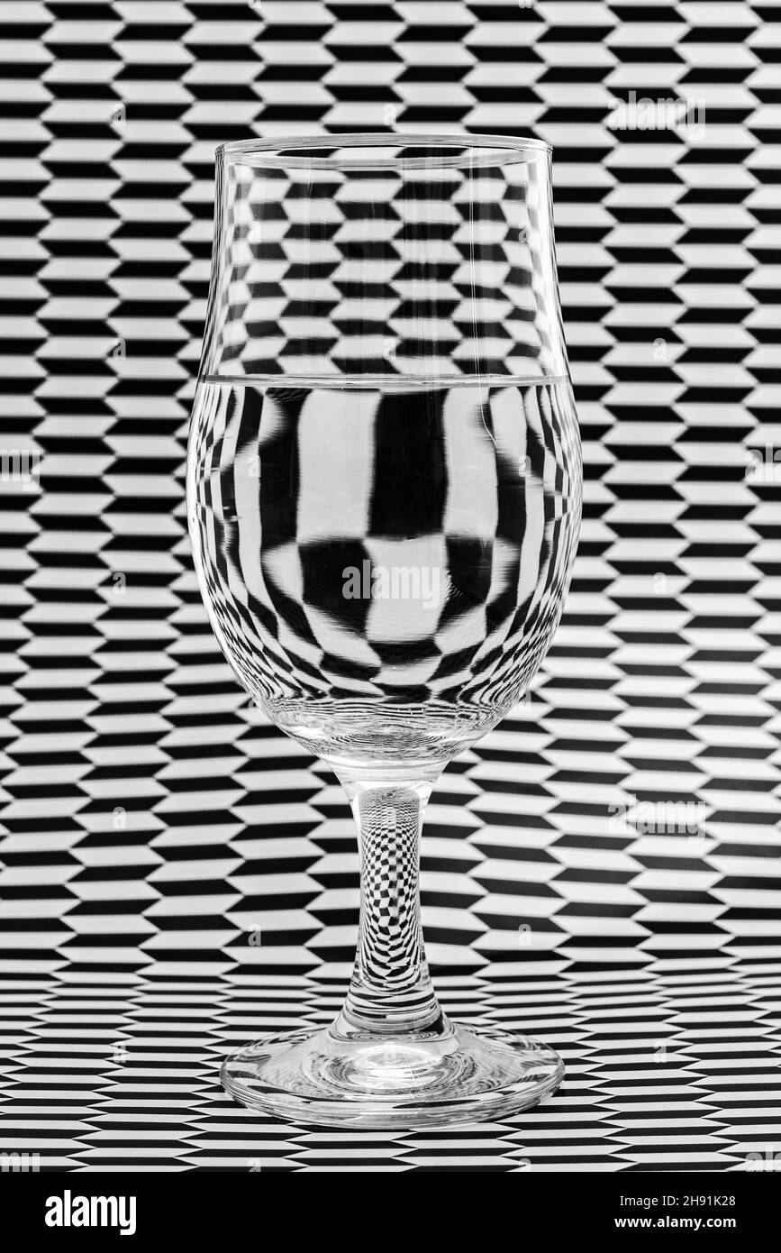 Image artistique de papier à motifs noir et blanc se réfractant à travers un verre et créant des motifs et des formes intéressants. Banque D'Images
