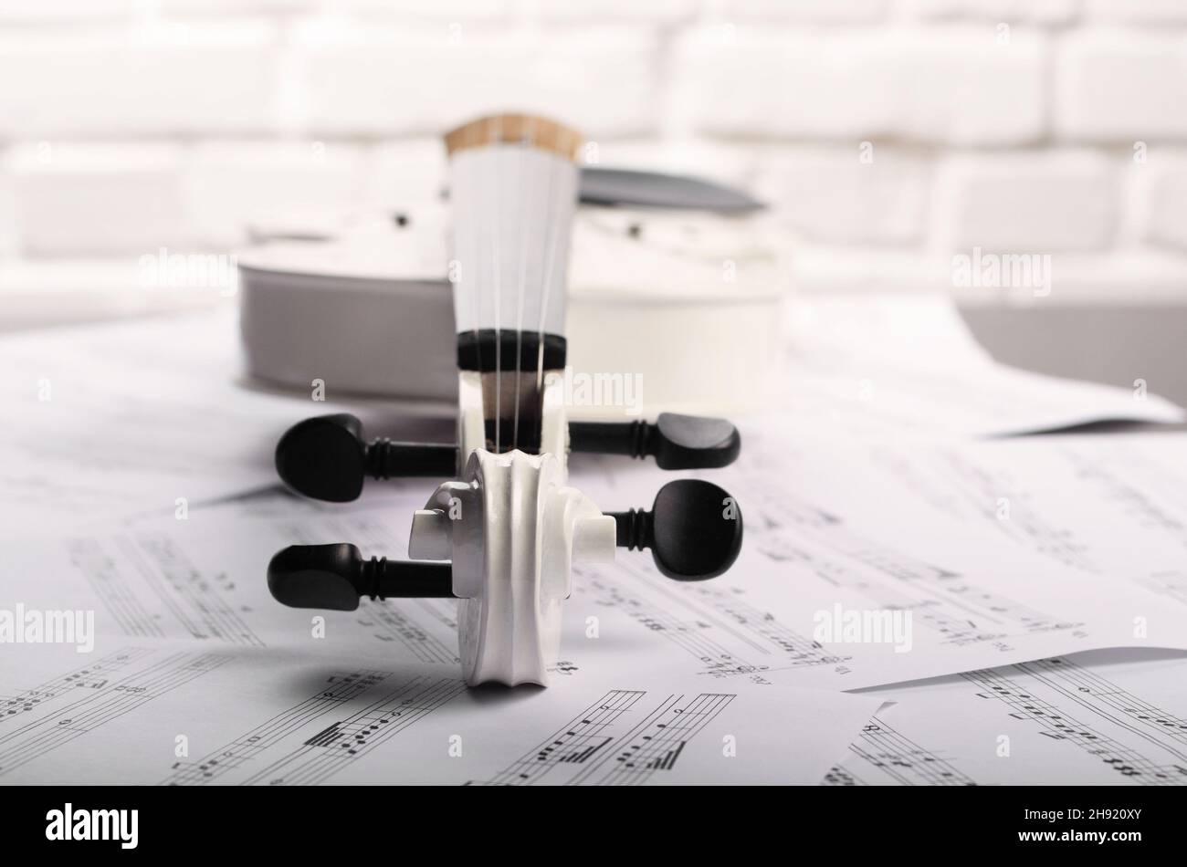 Fermer la vue d'un violon et des notes de musique près de white brick wall Banque D'Images