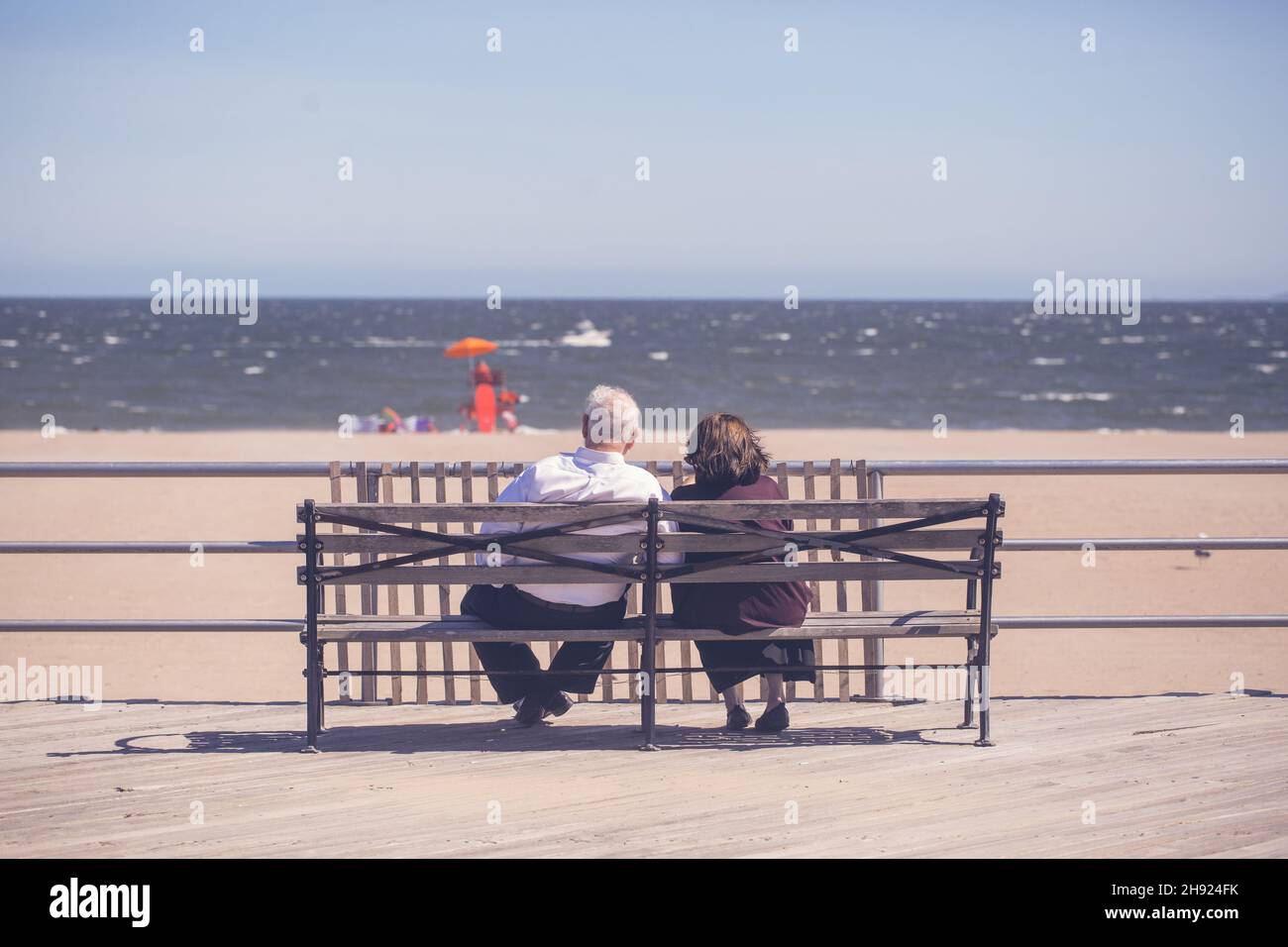 Vue panoramique d'un vieux couple assis sur le banc par temps ensoleillé Banque D'Images