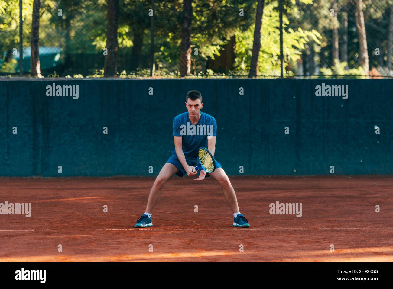 Athlète masculin concentré en attente de recevoir le ballon dans un jeu de tennis professionnel Banque D'Images