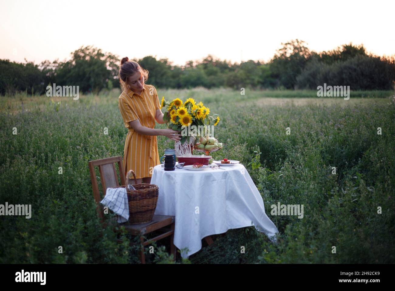 jardin et encore la vie. thé dans le jardin - fille et bouquet avec des tournesols sur la table Banque D'Images