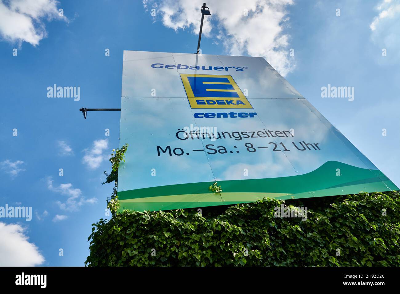 Göppingen, Allemagne - 21 mai 2020 : panneau d'affichage Edeka, sur une base verte avec ciel bleu et nuages.Goeppingen. Banque D'Images