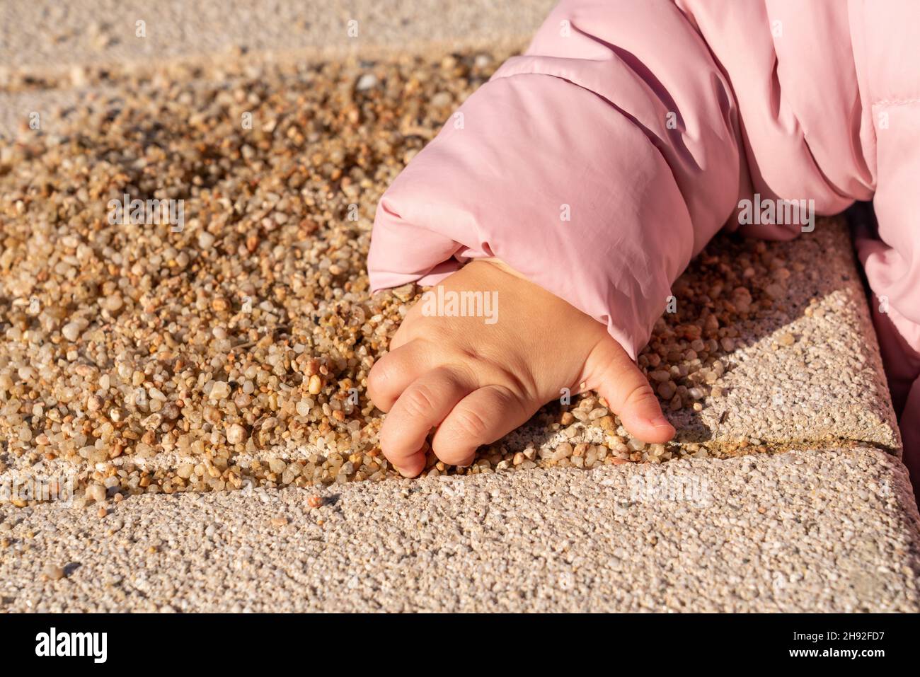 la main des enfants prend une poignée de sable Banque D'Images