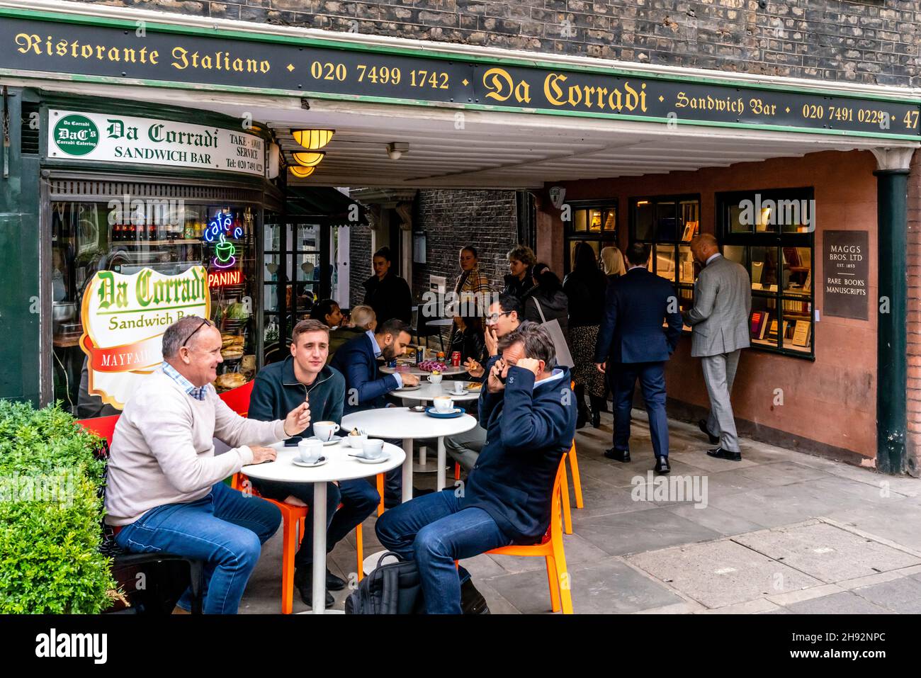 Personnes assises devant le Da Corradi Sandwich Bar à l'entrée du marché Shepherd, Londres, Royaume-Uni. Banque D'Images