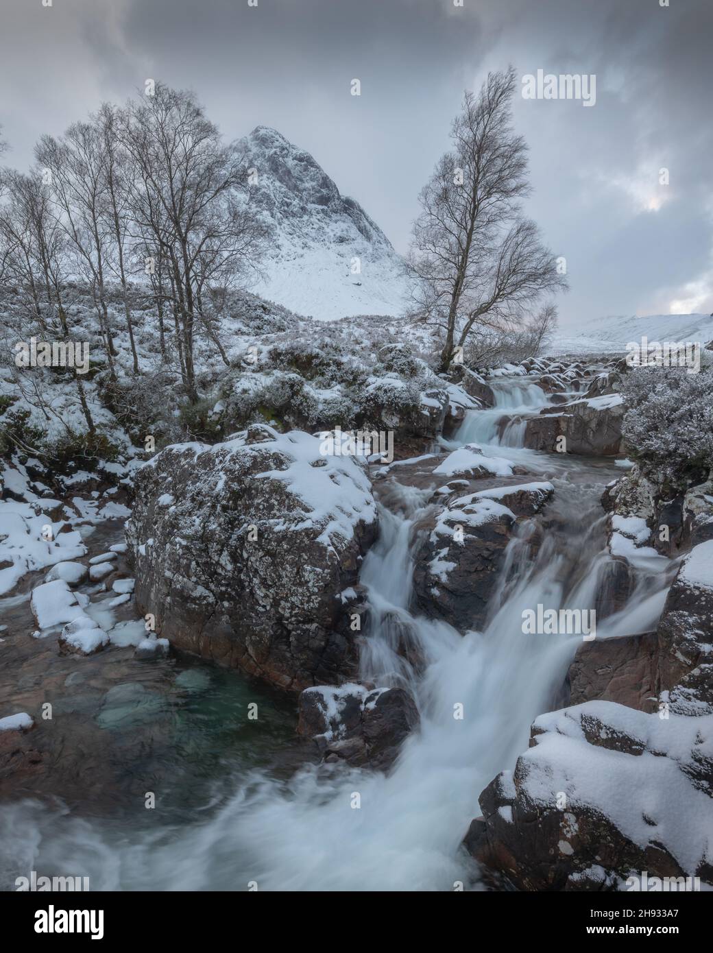 La rivière Frozen Coupall passe le long de Stob Dearg (le sommet le plus important de Buachille Etive More) lors d'une journée hivernale à Glencoe, en Écosse, au Royaume-Uni. Banque D'Images
