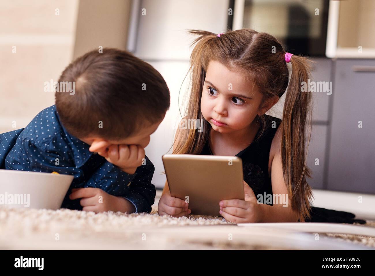 Belle enfant petite fille avec des queues de cheval regardant étrange à son frère. Banque D'Images