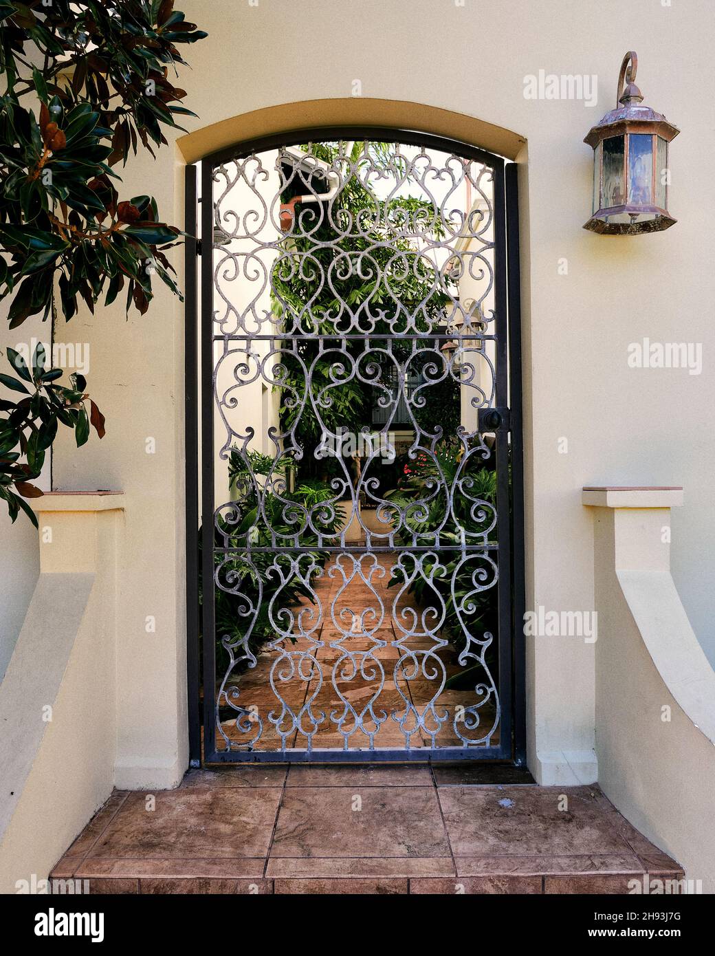 Porte d'entrée en fer métallique très ornée menant à une cour d'une maison de ville de Rosemary Beach, Floride, États-Unis. Banque D'Images