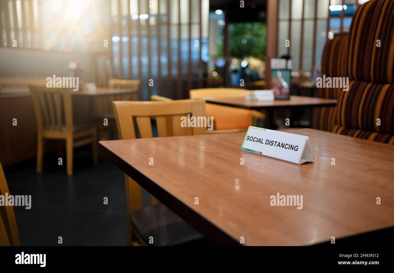 Tableau de signes de distance sociale sur la table du restaurant.Pandémie du virus Corona. Banque D'Images