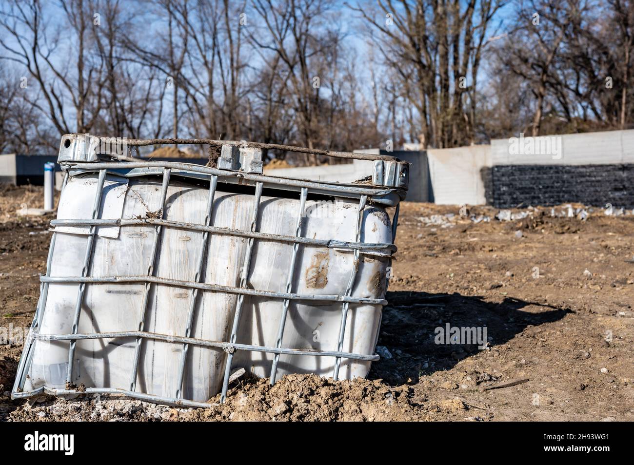 Fourre-tout en plastique en vrac endommagé abandonné sur un site de construction industrielle Banque D'Images