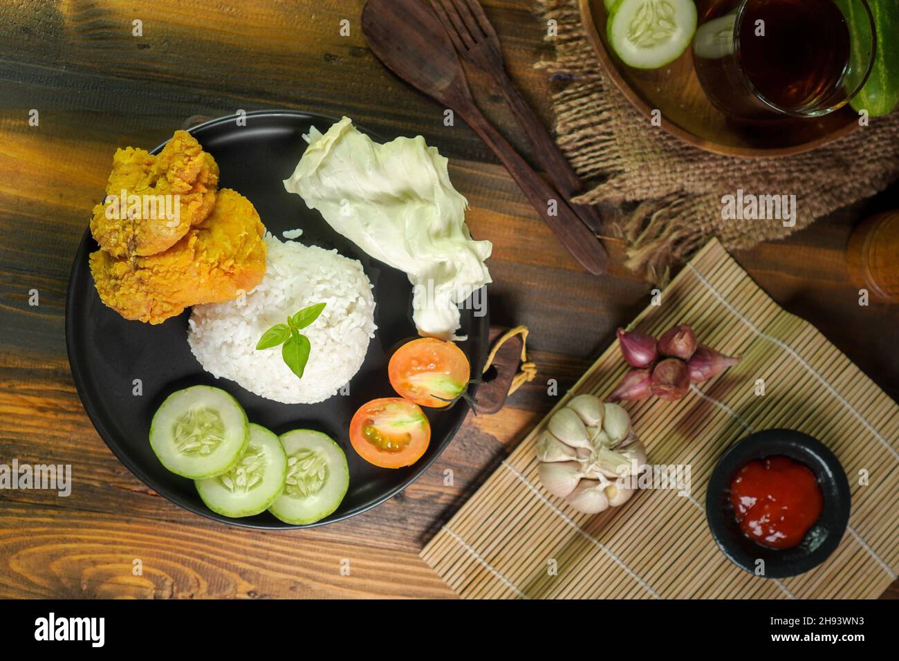 Ayam geprek est un poulet frit croustillant indonésien écrasé et mélangé avec des sambal chauds et épicés. Banque D'Images