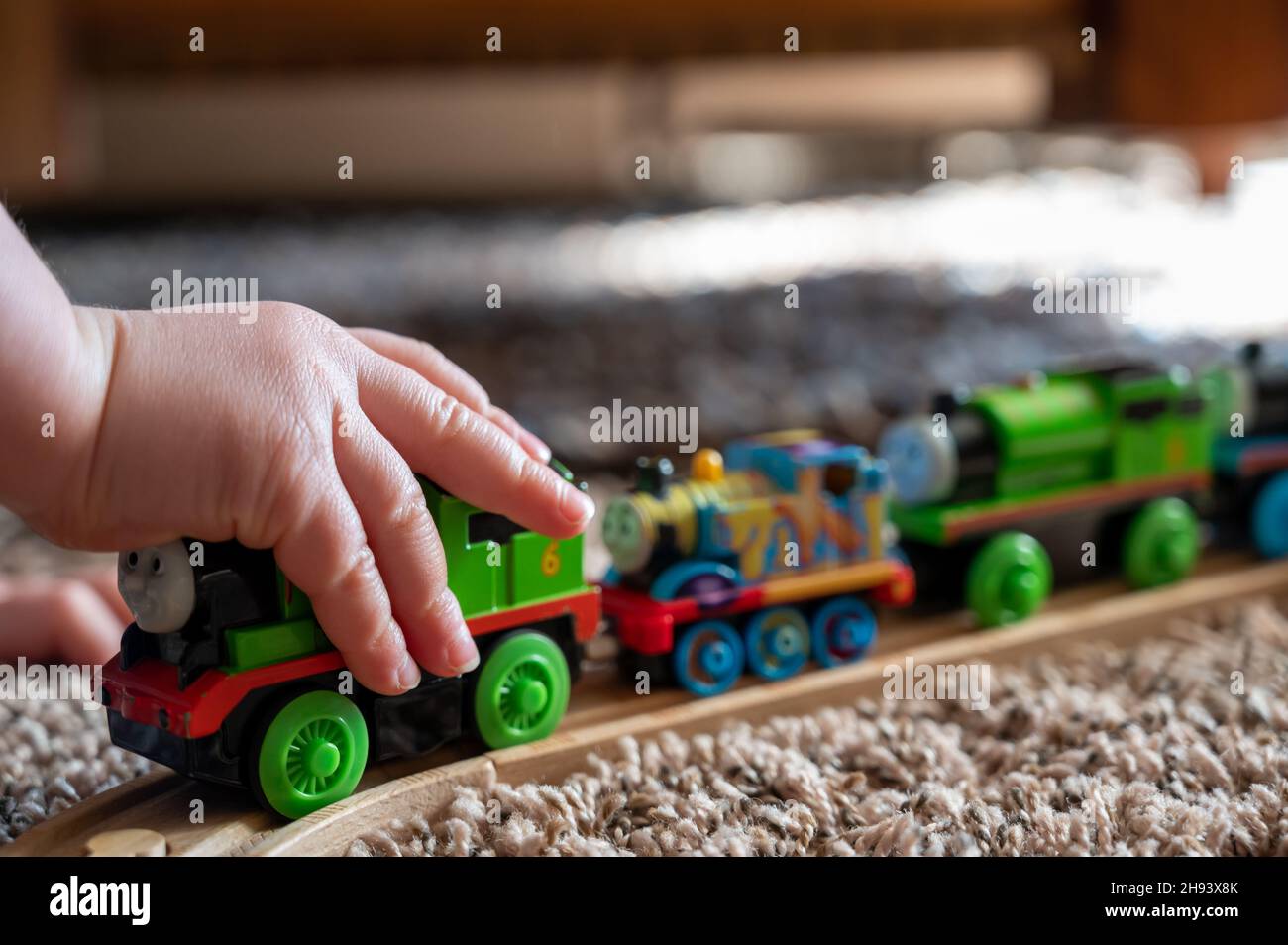 Tiffin, Iowa, Etats-Unis - 3.2021: Petit garçon jouant avec un modèle Thomas le train.Thomas est un jouet populaire sur le thème du chemin de fer pour enfants. Banque D'Images