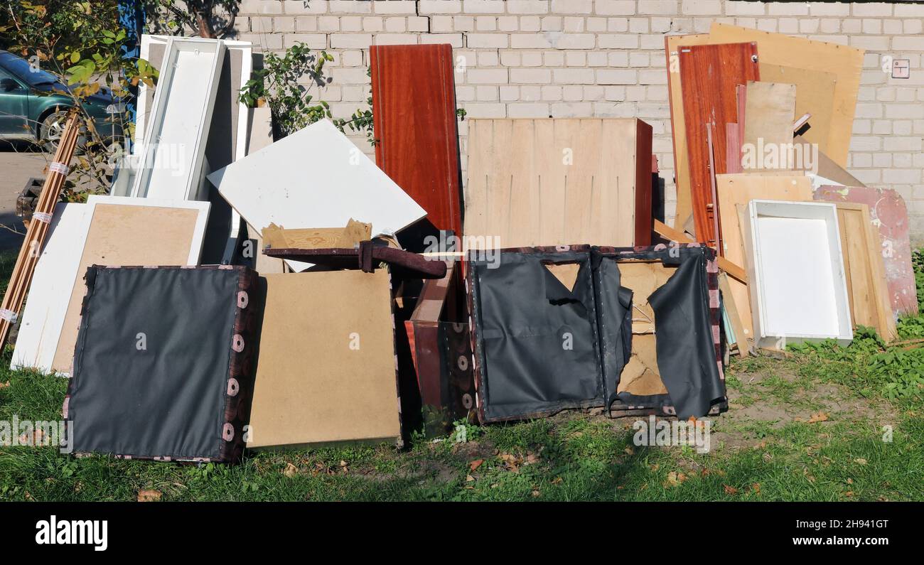 Vieux meubles cassés à la décharge à ordures près de la maison en briques Banque D'Images