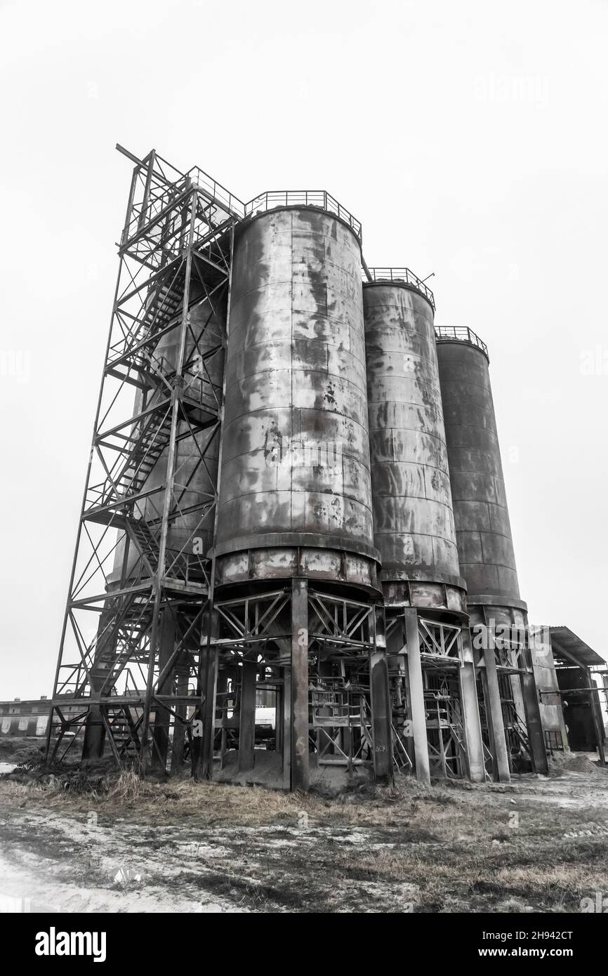 Alimenter l'ancien réservoir de produit chimique en huile de baril dans une usine industrielle abandonnée. Banque D'Images