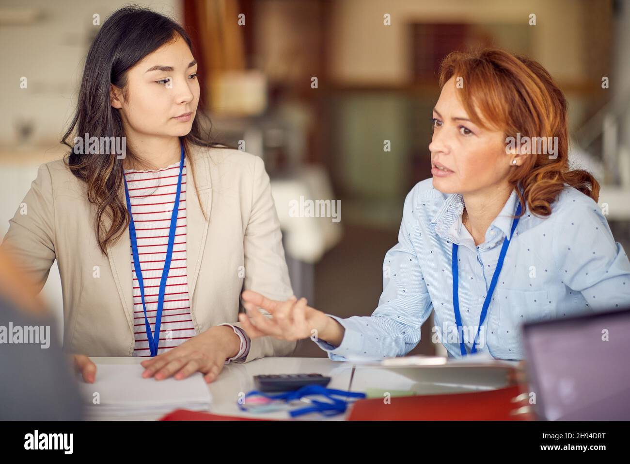 Deux femmes d'affaires élégantes assises dans une atmosphère de travail au bureau et ayant une conversation sur le travail.Entreprise, personnes, entreprise Banque D'Images
