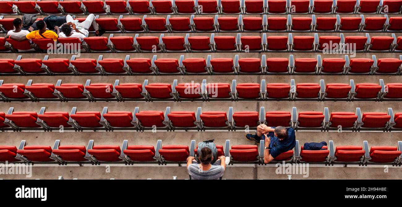 les spectateurs du stade assis dans des sièges rouges regardent le match Banque D'Images