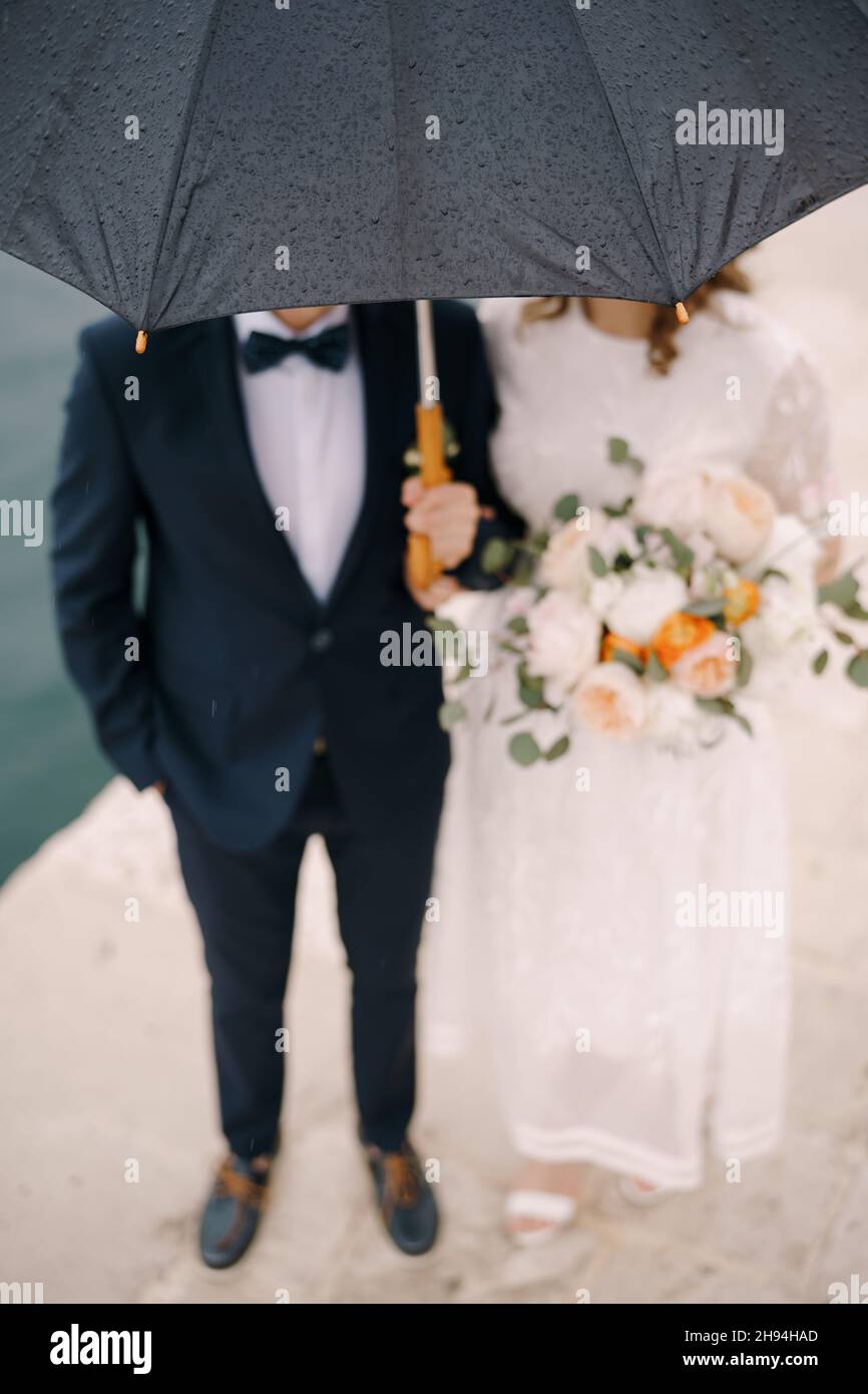 Des gouttes de pluie sur un parapluie au-dessus de la mariée et du marié.Flou.Gros plan Banque D'Images