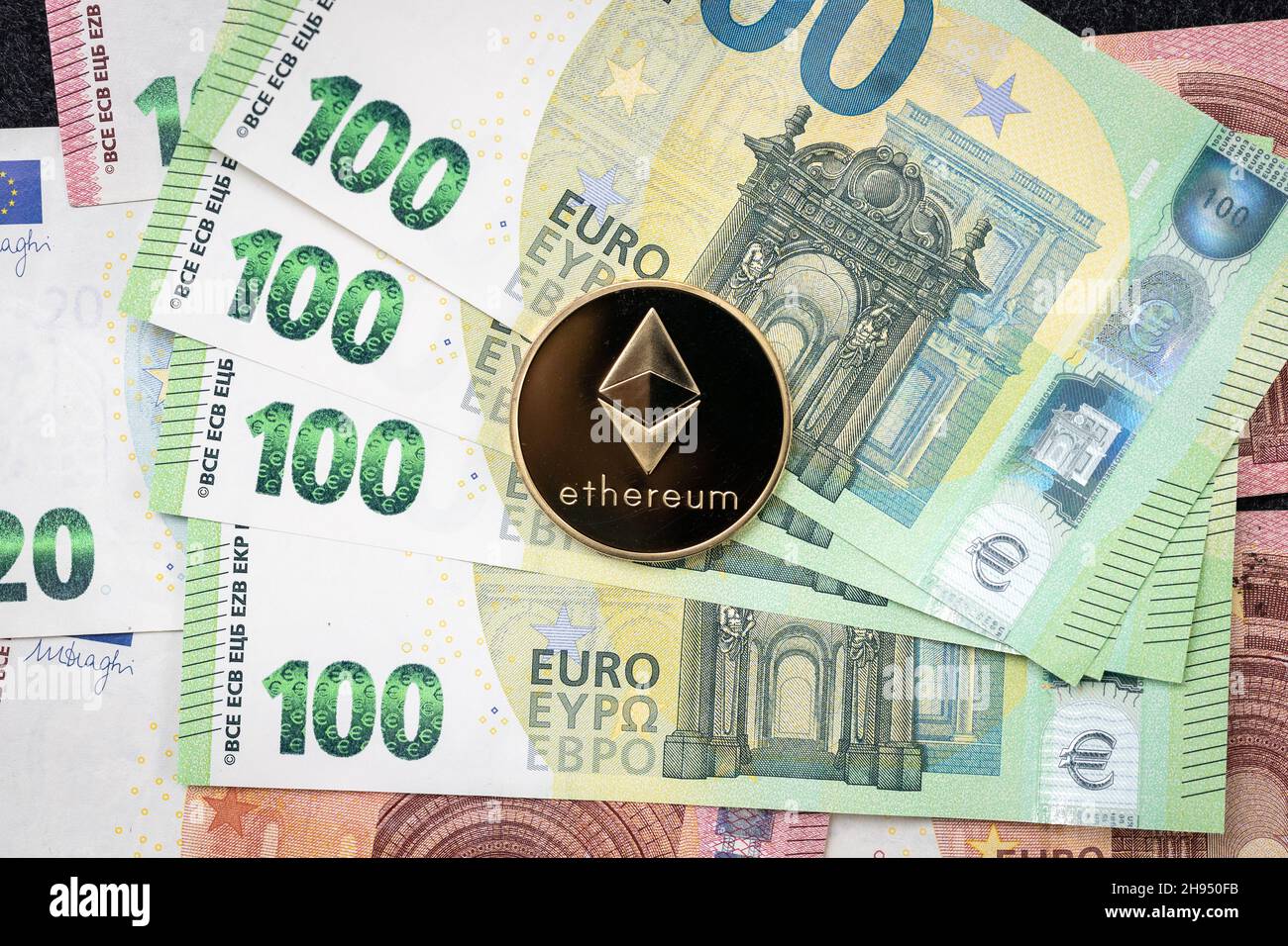 Pièce de monnaie physique Ethereum qui s'élève au-dessus des factures de 100 euros. Banque D'Images