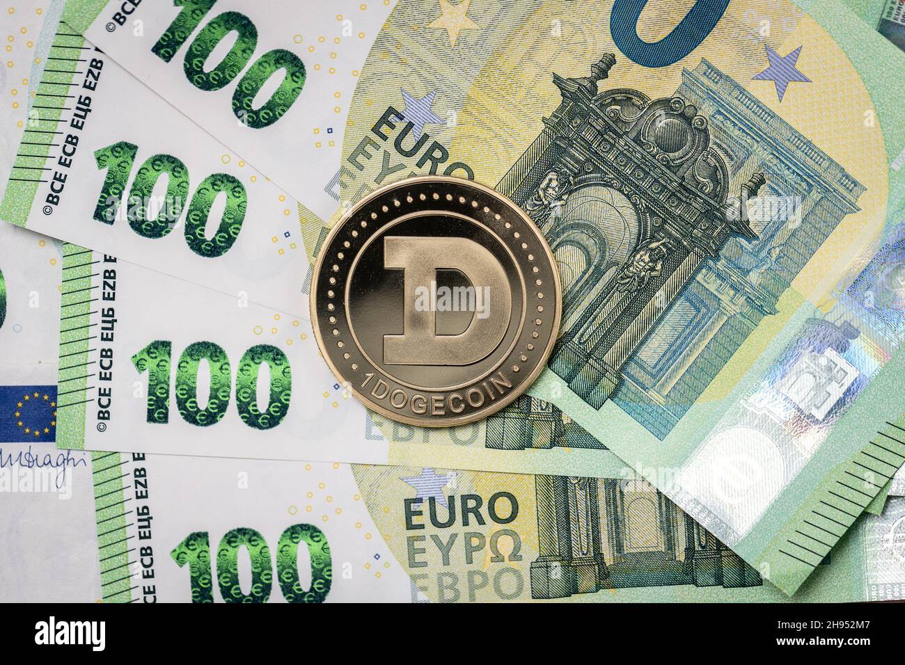 Pièce de monnaie physique Dogecoin qui s'élève au-dessus des billets de 100 euros. Banque D'Images