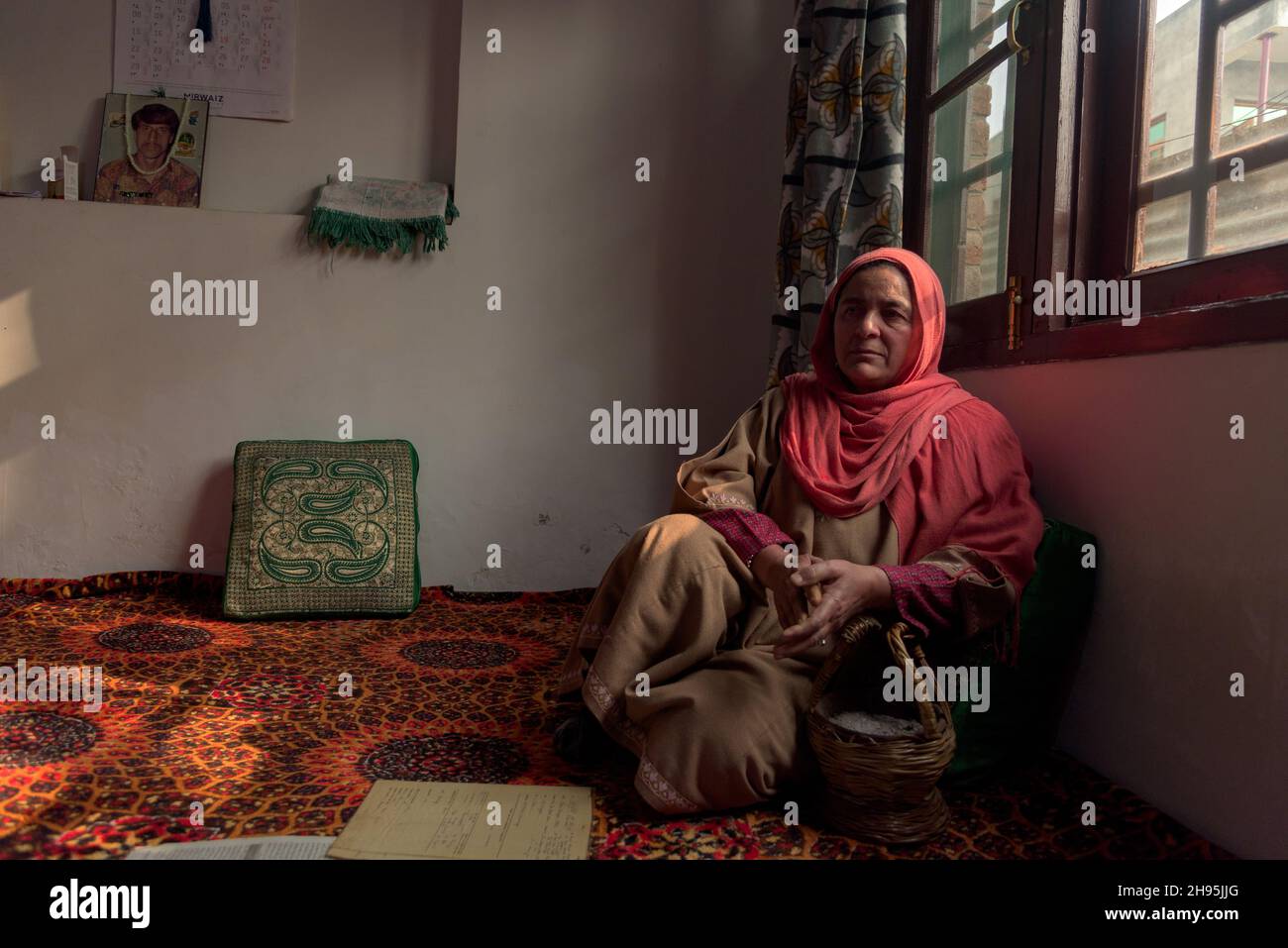 Jameela Bano pose des photos à sa résidence.en octobre, un tribunal de Srinagar a ordonné la formation d'une équipe d'enquête spéciale pour enquêter sur une précédente équipe d'enquête spéciale qui n'a pas établi la vérité sur le meurtre par la police de Mohammad Ramzan Bhat, un motard de 1996 dans la capitale de Jammu-et-Cachemire.Malgré les conclusions post-mortem et les rapports de la commission des droits de l'homme qui ont déclaré que Bhat's était un meurtre extrajudiciaire, Jameela Bano (épouse de Mohammad Ramzan Bhat) a dû frapper à la porte du pouvoir judiciaire pendant plus de deux décennies.La veuve de Mohammad Ramzan Bhat, soi-disant tué dans un incendie à Banque D'Images