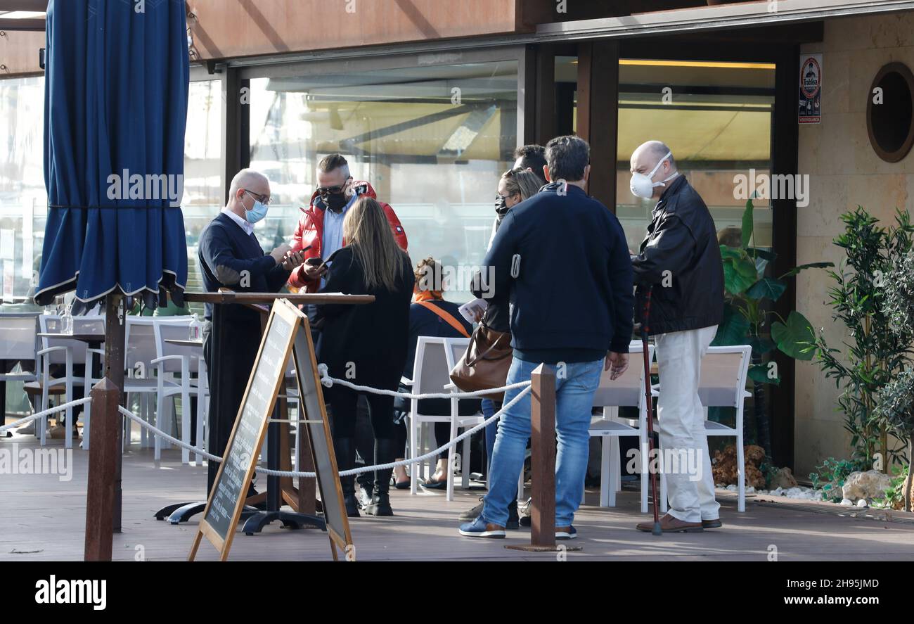 Palma, Espagne.04e décembre 2021.Les clients montrent Artur, serveur au Bar Pesquero, leur certificat numérique Covid.Pour visiter des bars, des restaurants et d'autres établissements d'une capacité de plus de 50 personnes, un certificat de vaccination ou de convalescence ou un résultat de test négatif doit être présenté depuis 04.12.2021.Credit: Clara Margais/dpa/Alay Live News Banque D'Images