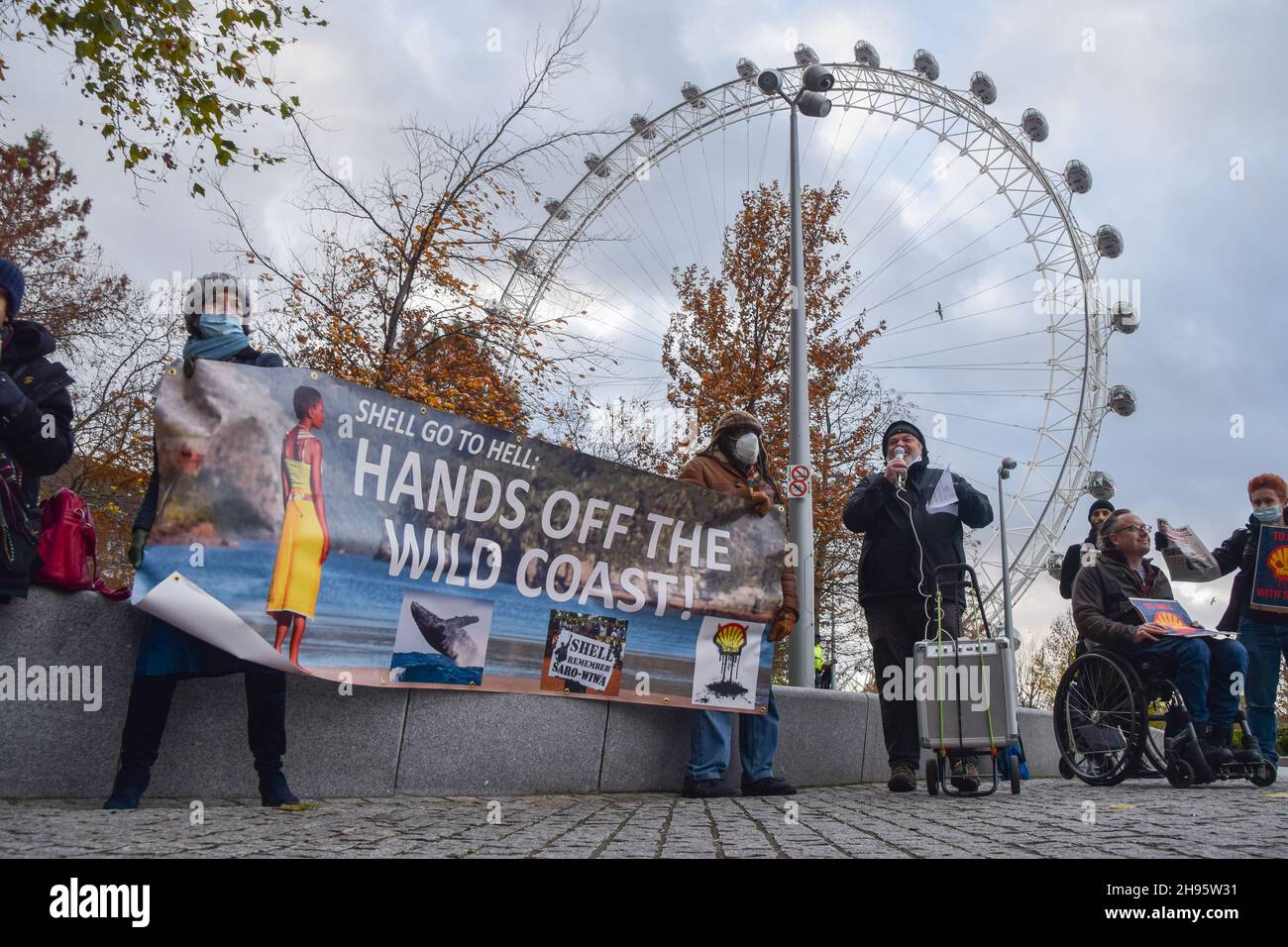 Londres, Royaume-Uni.04e décembre 2021.Les activistes tiennent une bannière « mains off the Wild Coast » à côté du London Eye pendant la manifestation.des manifestants se sont rassemblés devant le siège social de Shell à Londres, pour protester contre l'étude sismique du géant pétrolier sur la Wild Coast en Afrique du Sud, qui va nuire considérablement à la faune et aux écosystèmes marins.Crédit : SOPA Images Limited/Alamy Live News Banque D'Images
