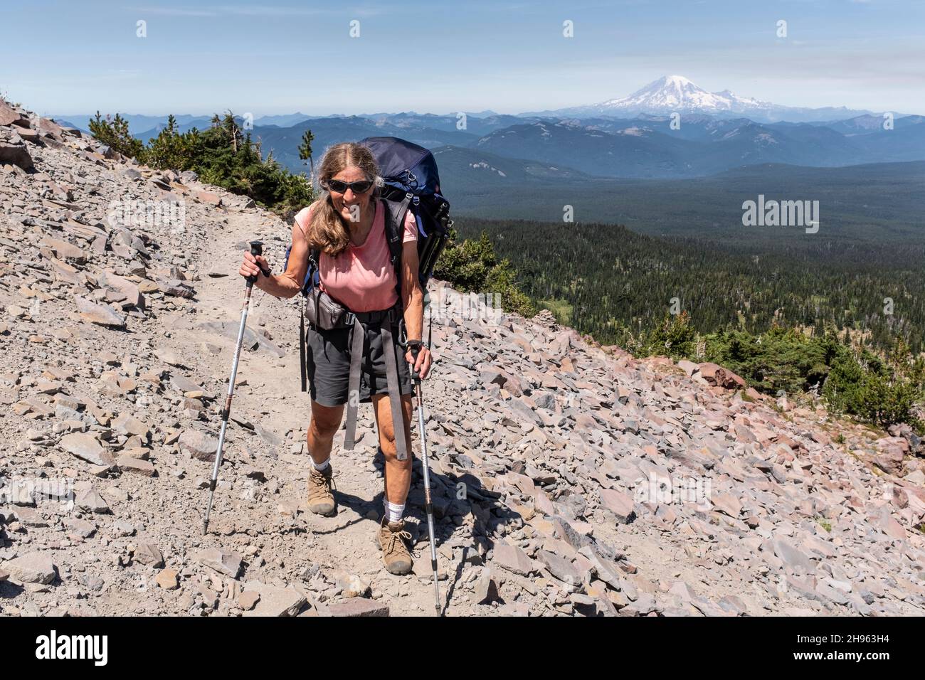 WA20471-00....WASHINGTON - Vicky Spring randonnée près de High Camp dans la nature sauvage de Mount Adams avec Mount Rainier au loin. Banque D'Images