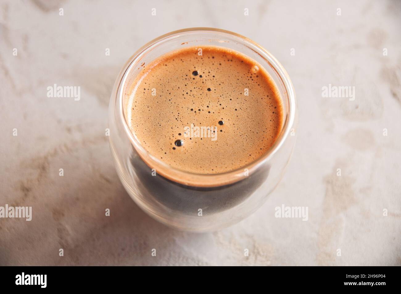 Vue de dessus du café en verre avec des murs doubles sur fond de béton Banque D'Images