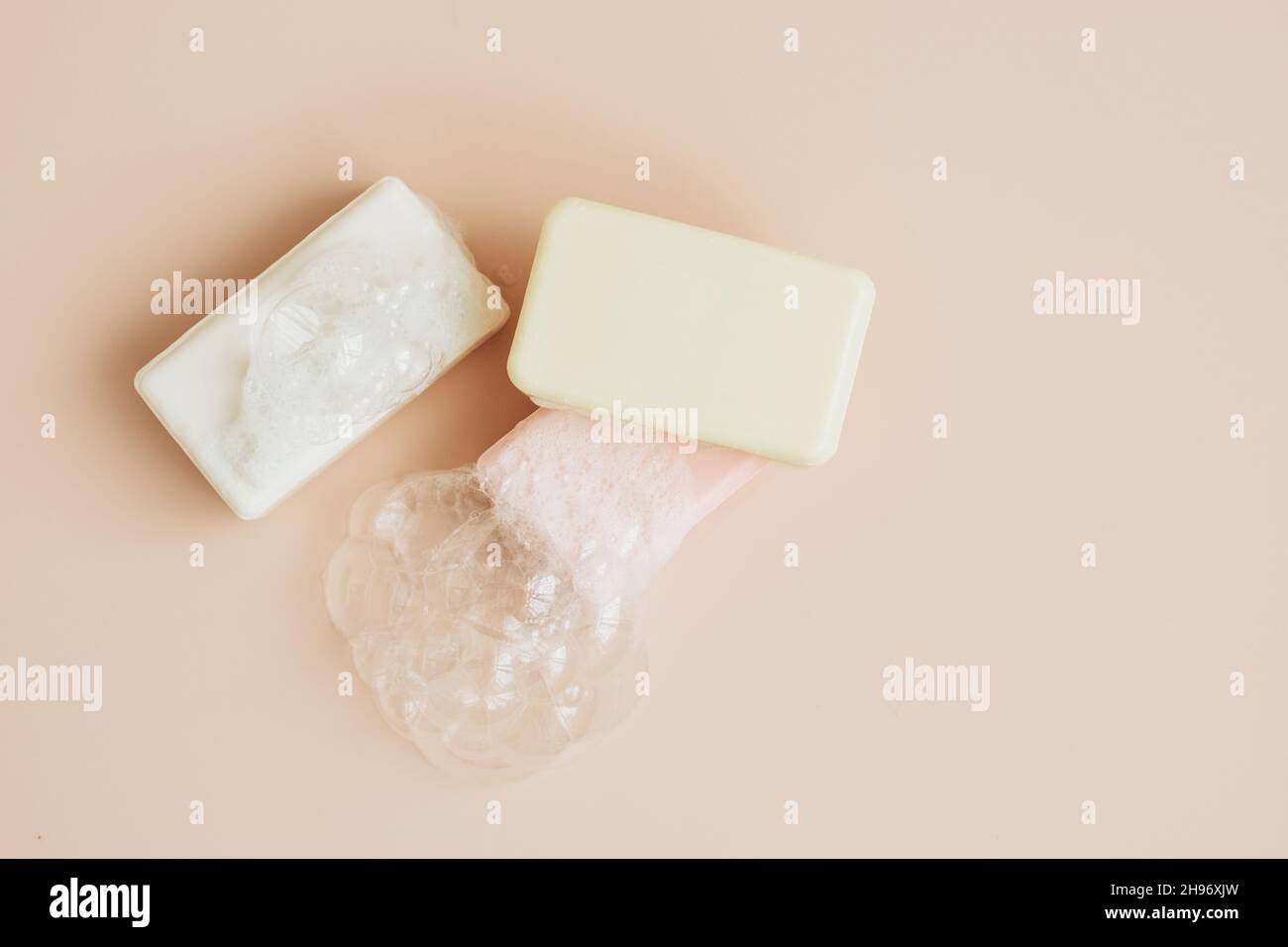 Savon naturel bio fait à la main avec de grandes bulles de mousse sur fond pastel.Santé beauté produits naturels concept. Banque D'Images